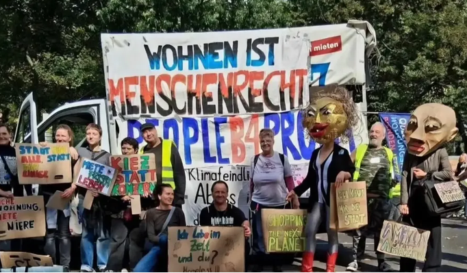 Teilnehmende der Demonstration ‚Her mit den Wohnungen!‘ am 5. September 2026 vor dem Roten Rathaus in Berlin mit Protestplakaten und einem großen Banner ‚Wohnen ist Menschenrecht‘.